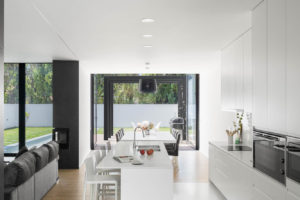 Bílá kuchyň a obývací část v moderním domě