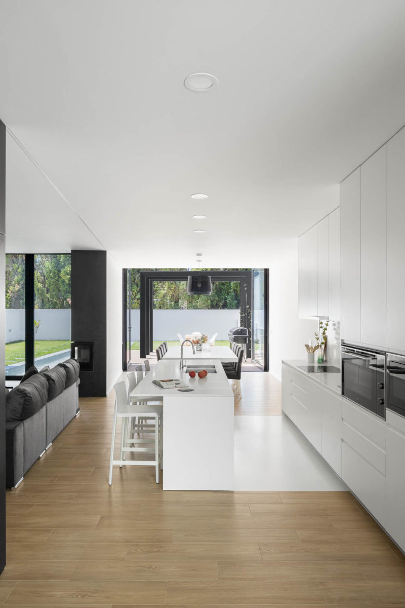 Bílá kuchyň a obývací část v moderním domě