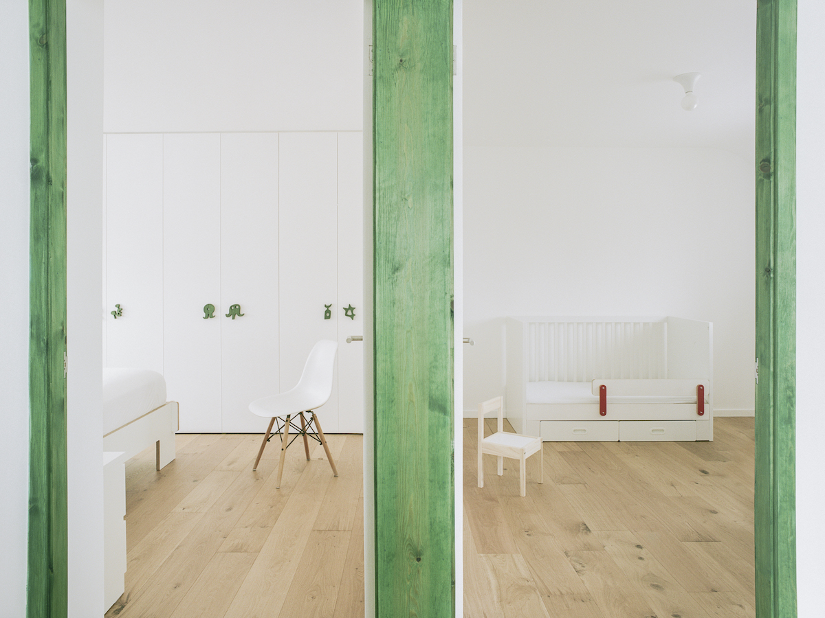 Bílý interiér bytu se zelenými rámy a obkladem