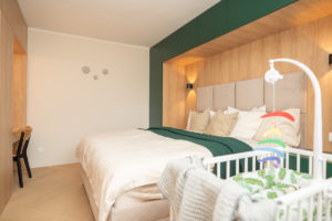 Hotelový styl ložnice s dětskou postýlkou