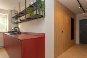 Rudá úzká kuchyň pohled z chodby v bytě