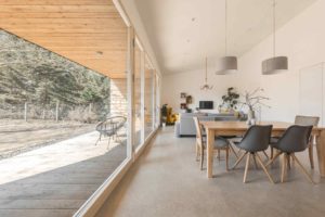 Příjemný minimalistický obývák a jídelna s prosklením na terasu domu