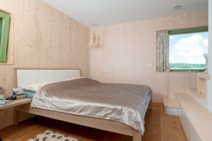 Jednoduchá ložnice v dřevostavbě