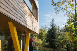 Dřevěná hranatá novostavba se žlutými rámy