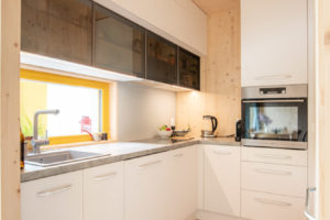 Bílá kuchyň s dřevěnou podlahou