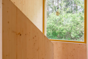 Dřevěné schodiště v domě s velkým oknem