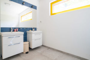 Koupelna se žlutým oknem a modrou stěnou