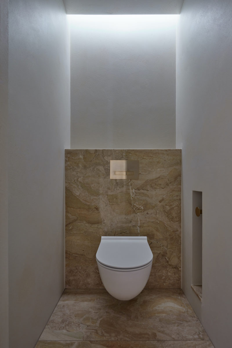 Světlá podsvícená toaleta s mramorem