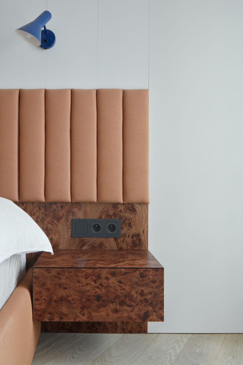Čalounená hnědá postel v artdeco ložnici s parketama