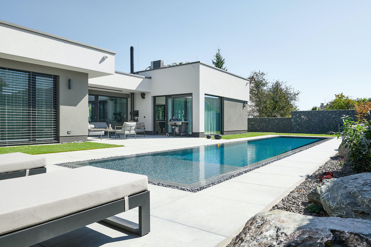 Moderní bílá přízemní vila s velkým prosklením terasou a bazénem