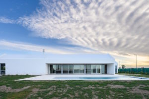 Bezbariérový bílý prosklený minimalistický dům s bazénem