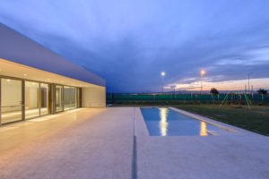 Bezbariérový bílý prosklený minimalistický dům s bazénem