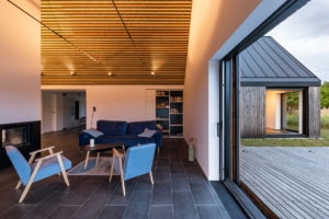 Interiér rodinného domu s prosklením dřevěným krovem a přírodními prvky