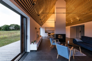Interiér rodinného domu s prosklením dřevěným krovem a přírodními prvky