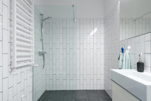 Bílá moderní koupelna se šedou dlažbou