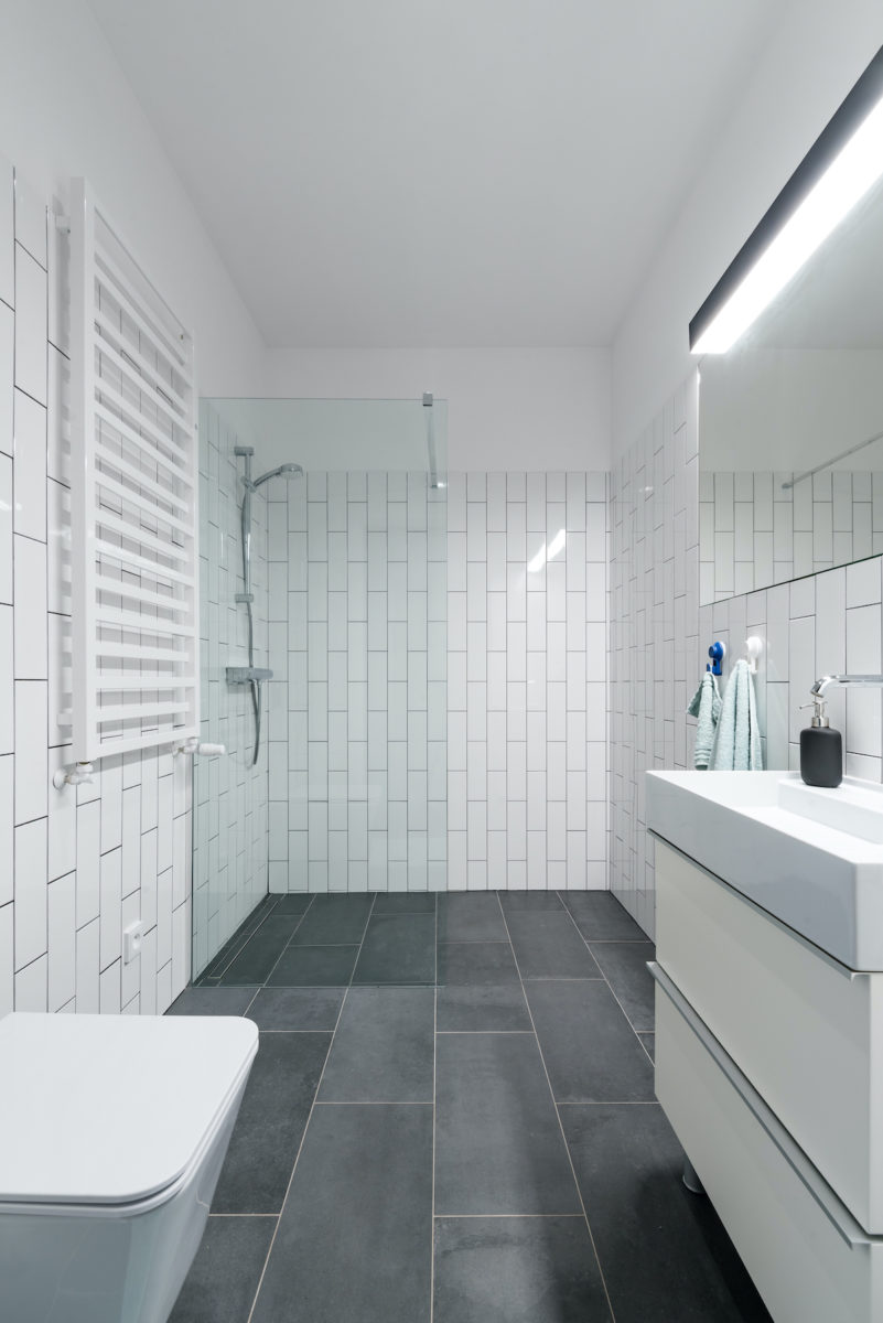 Bílá moderní koupelna se šedou dlažbou