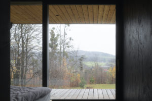 Přírodní interiér dřevostavby s terasou a výhledem do přírody