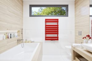 Bílá moderní koupelna s červeným radiatorem