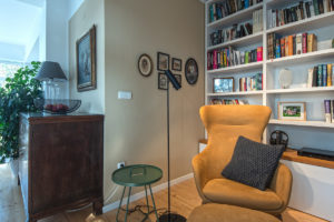 Obývací pokoj s knihovnou a horčicovým ušákem
