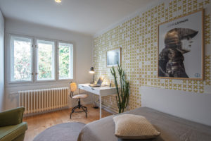Moderní pokoj pro hosty se vzorovanou tapetou