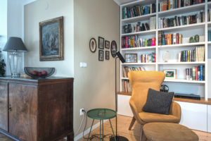 Obývací pokoj s knihovnou a horčicovým ušákem