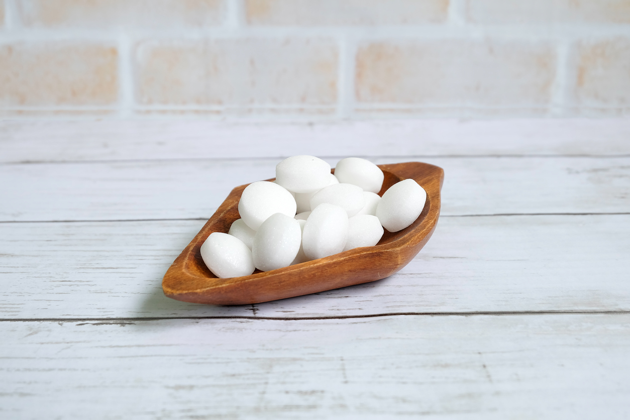 White naphthalene balls on white wooden background