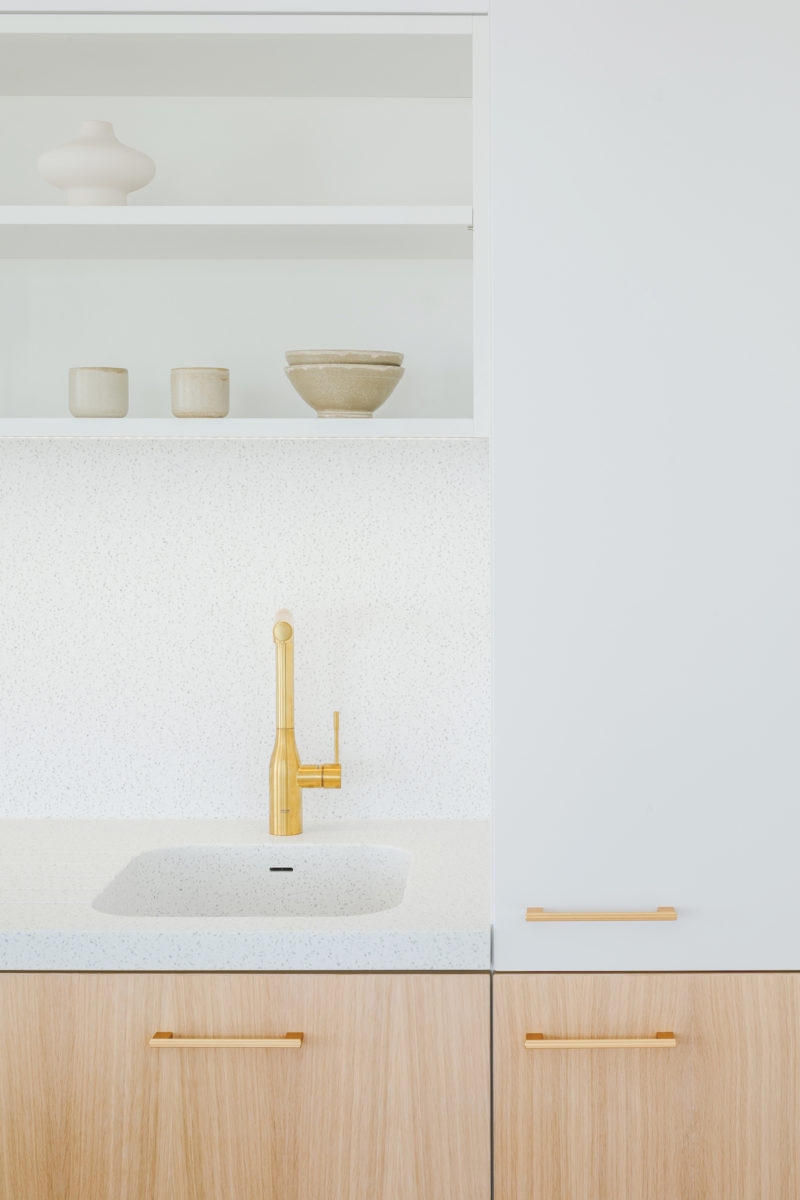 Minimalistický interiér kuchyně říznutý francouzským šarmem v bílé s dřevem