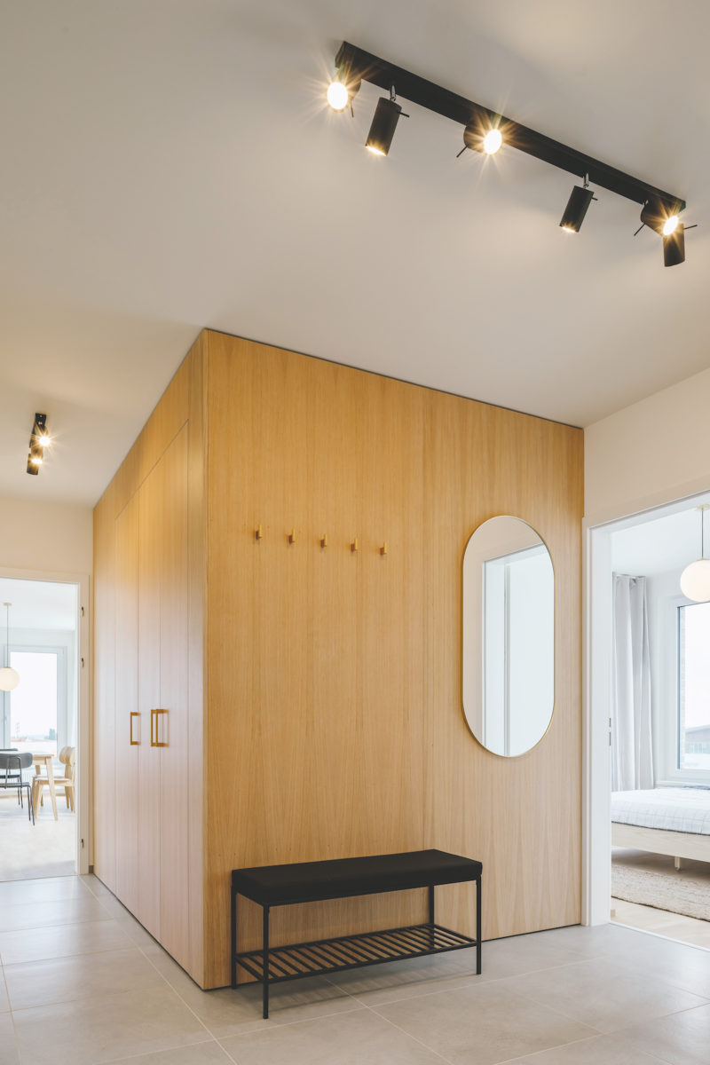 Minimalistický interiér říznutý francouzským šarmem v bílé s dřevem