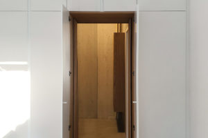 Detail vestavěné skříne v ložnici s přechodem do koupelny