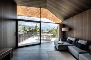 Obývací pokoj víkendové chaty s výhledem na Alpy