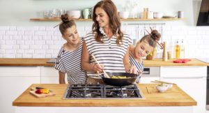 Žena varí s dcérami v kuchyni