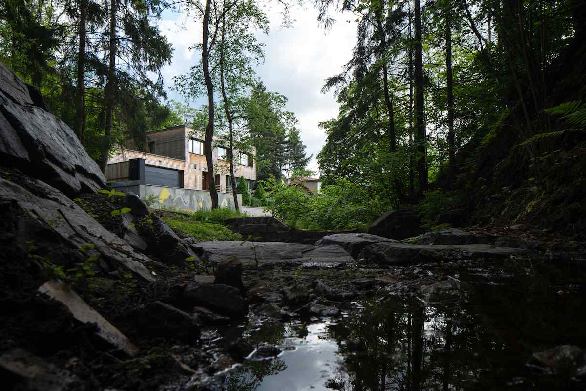 Hranatá dvoupodlažní stavba s modřínovou fasádou a velkými okny