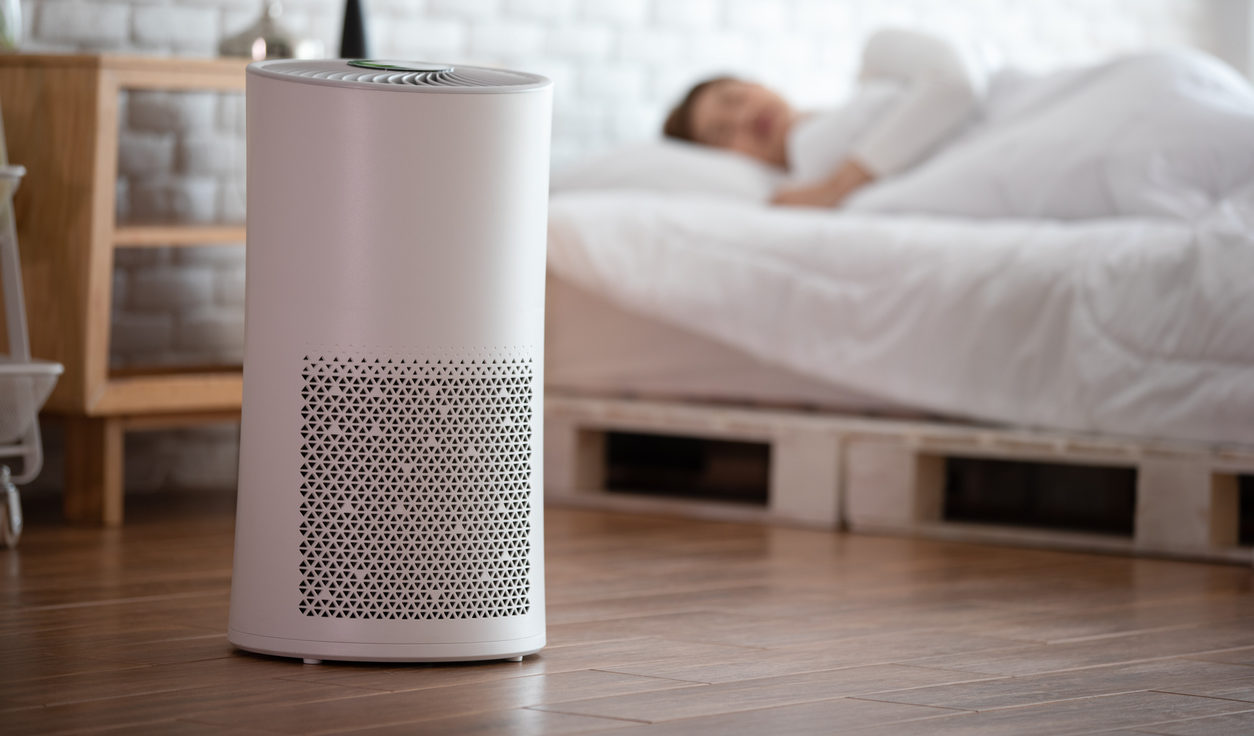 Woman sleep with Air purifier in cozy white bed room for filter and cleaning removing dust PM2.5 HEPA in home,for fresh air and healthy life,Air Pollution Concept