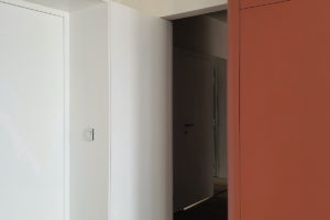 Moderní panelákový červeno bílý byt s boxem ve středu bytu