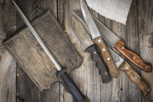 Dřevěné prkínko s brouskou a nože