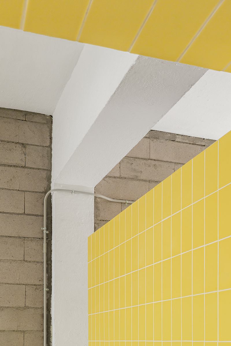 Žluté keramické obklady a betónová stěna - Dům MG08 v Madridu