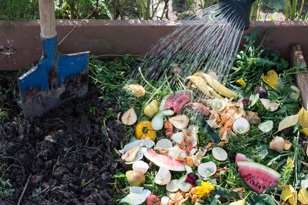 Zalévání složek kompostu v zahradě