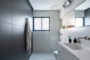 Úzká koupelna s černou stěnou - Vzdušný městský byt v Izraelu