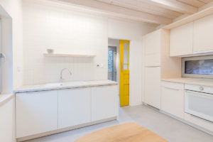 Minimalistická kuchyně se žlutými dveřmi - Dům v Modre