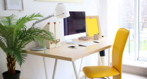 Pracovní stůl s kancelářskou žlutou židlí.