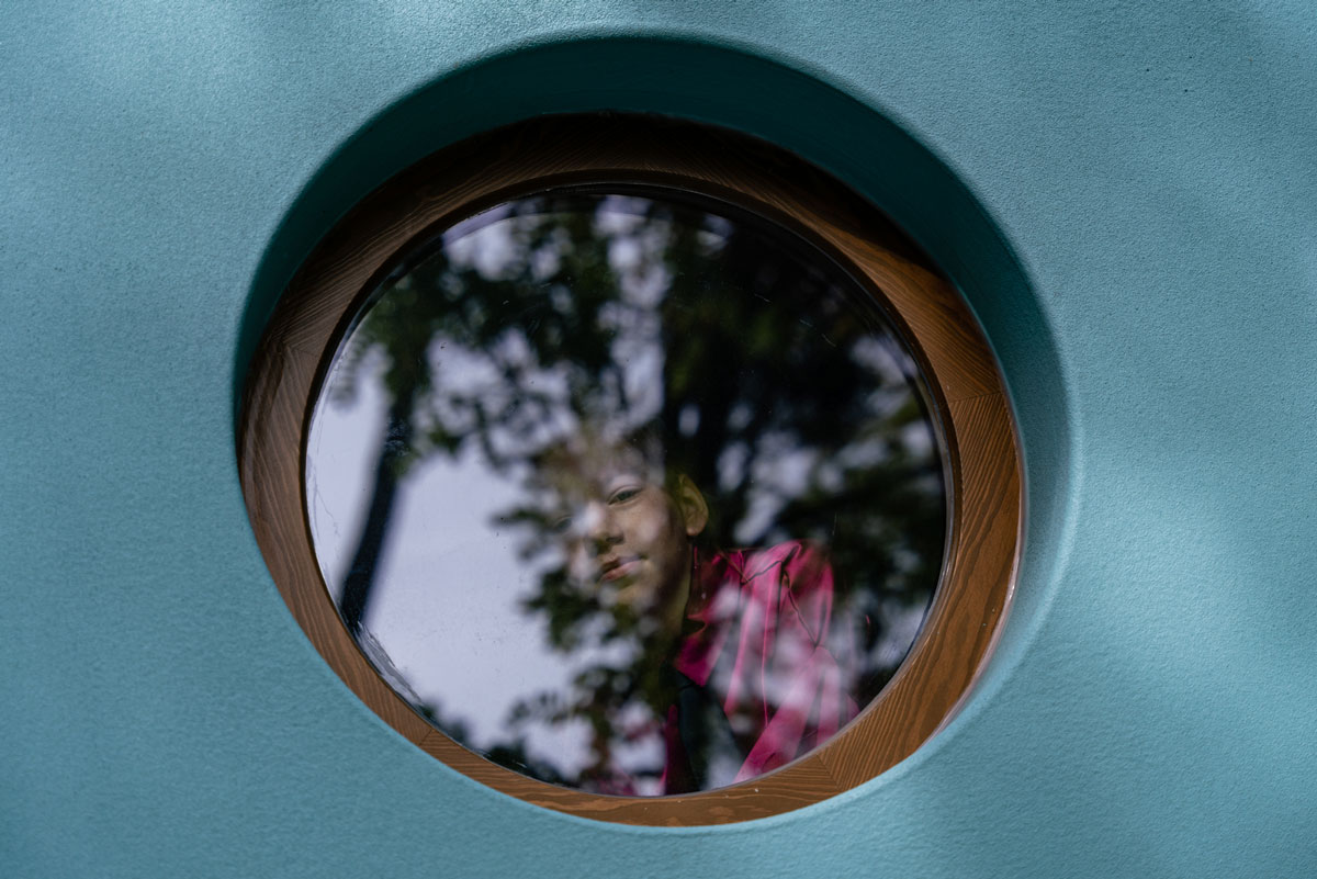 Dívka sedí za oknem .Letadlový dům 