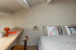 Stůl se židlí vedle postel-Grotta e Carrubo