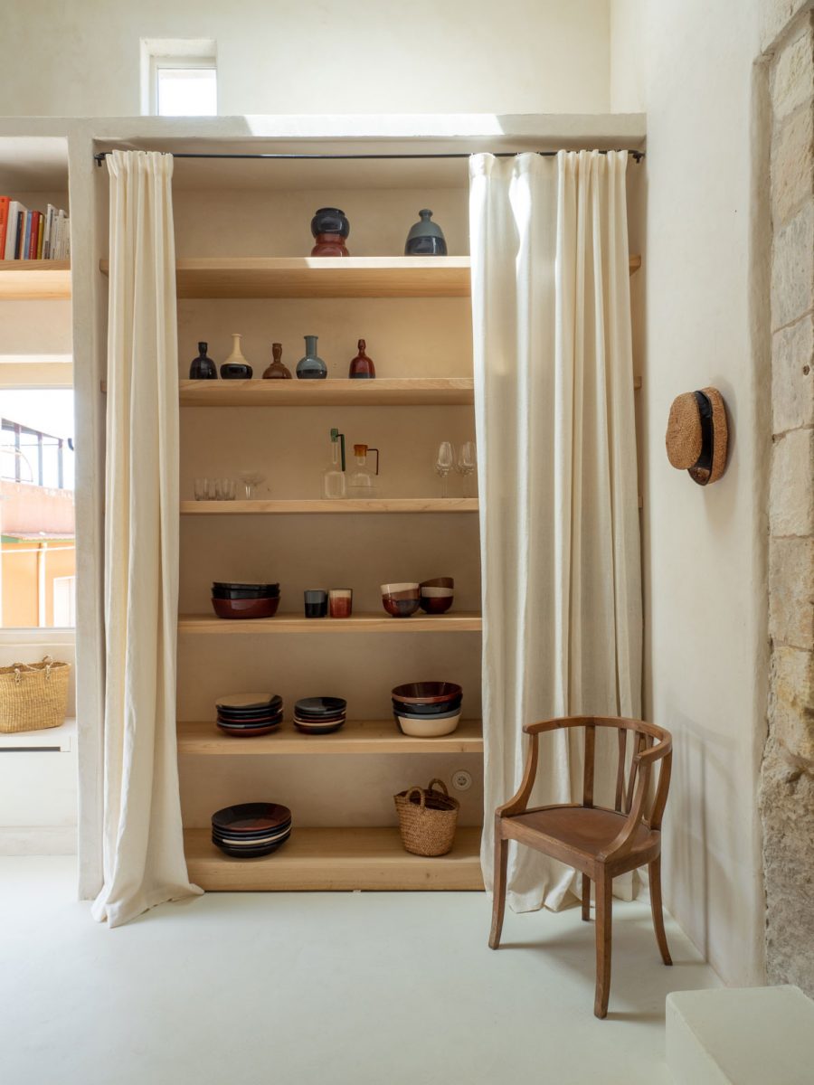 Dřevěná židle vedle skříně se záclony -Grotta e Carrubo