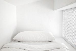 Bílá postel s povlečením -Industriální byt