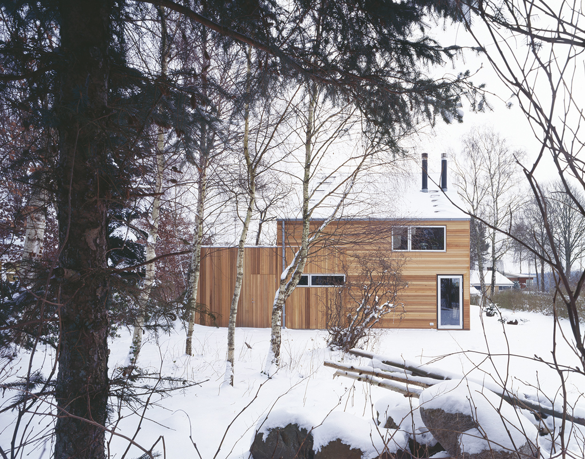 Moderní dům v lese s dřevěnou fasádou