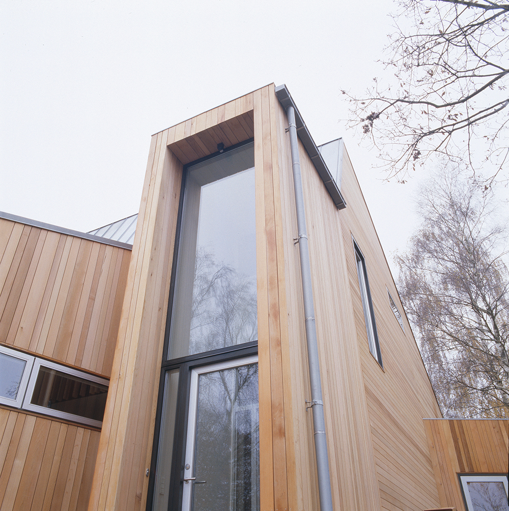 Moderní dům v lese s dřevěnou fasádou