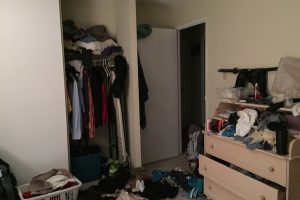 Neuklizená ložnice se spoustou oblečení