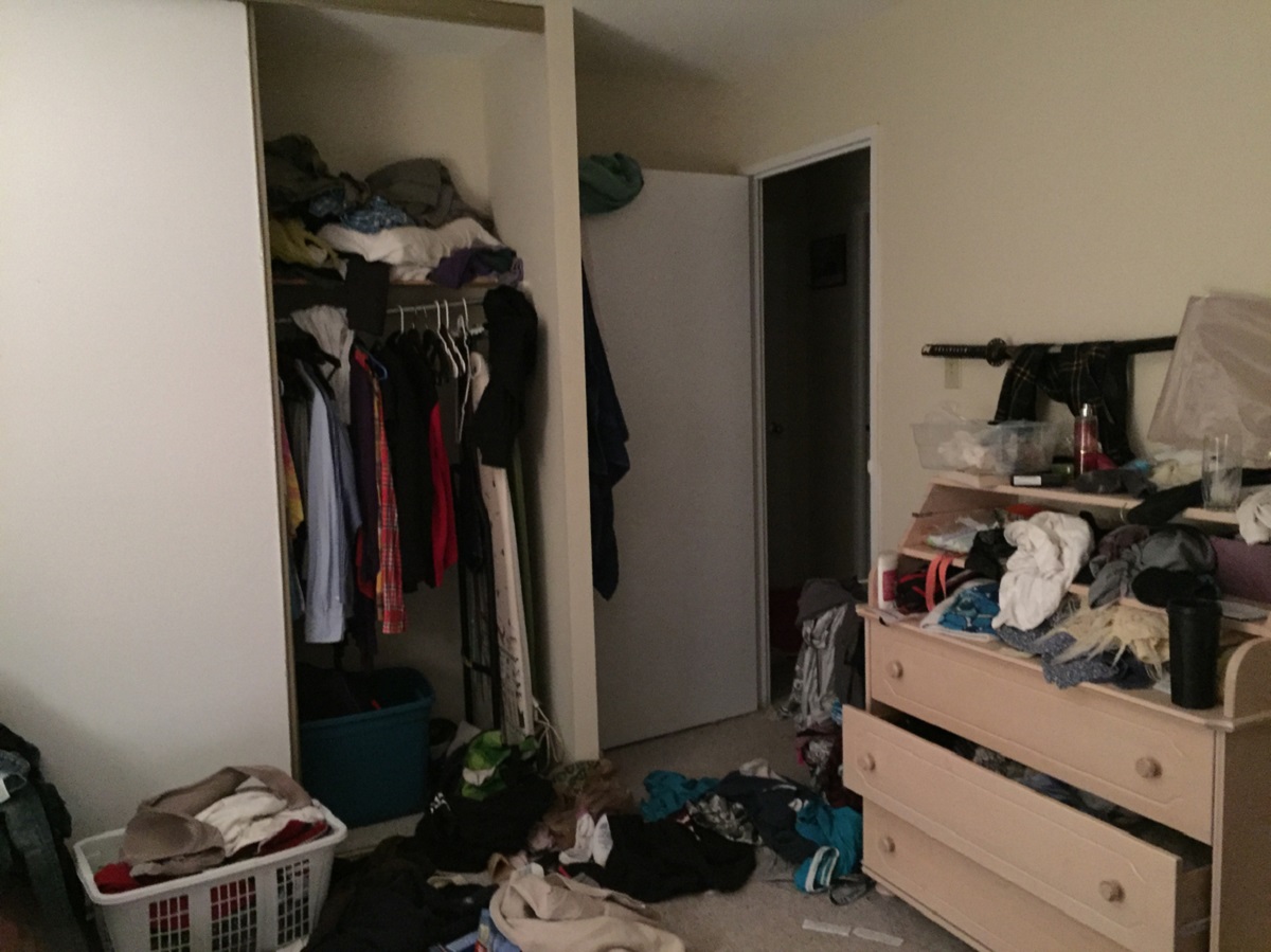Neuklizená ložnice se spoustou oblečení