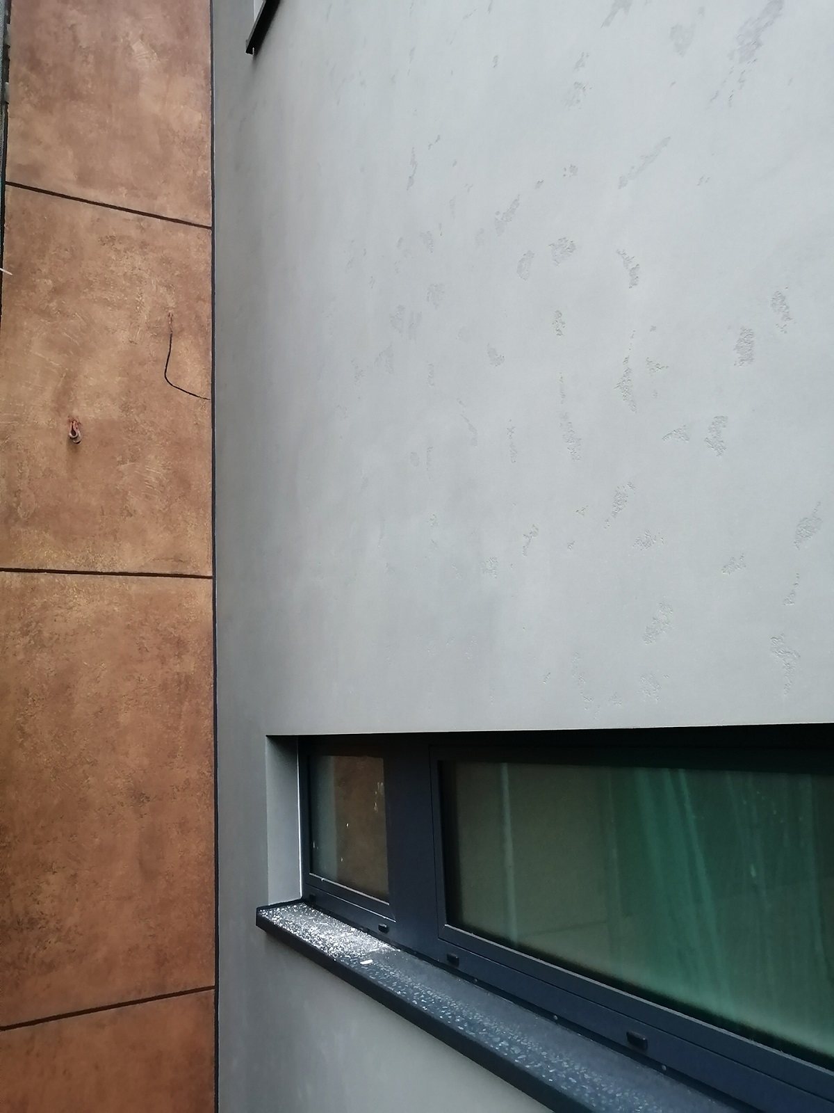 Realizace kreativní omítky – detail struktury „pohledový beton šedý“, Praha Holešovičky.