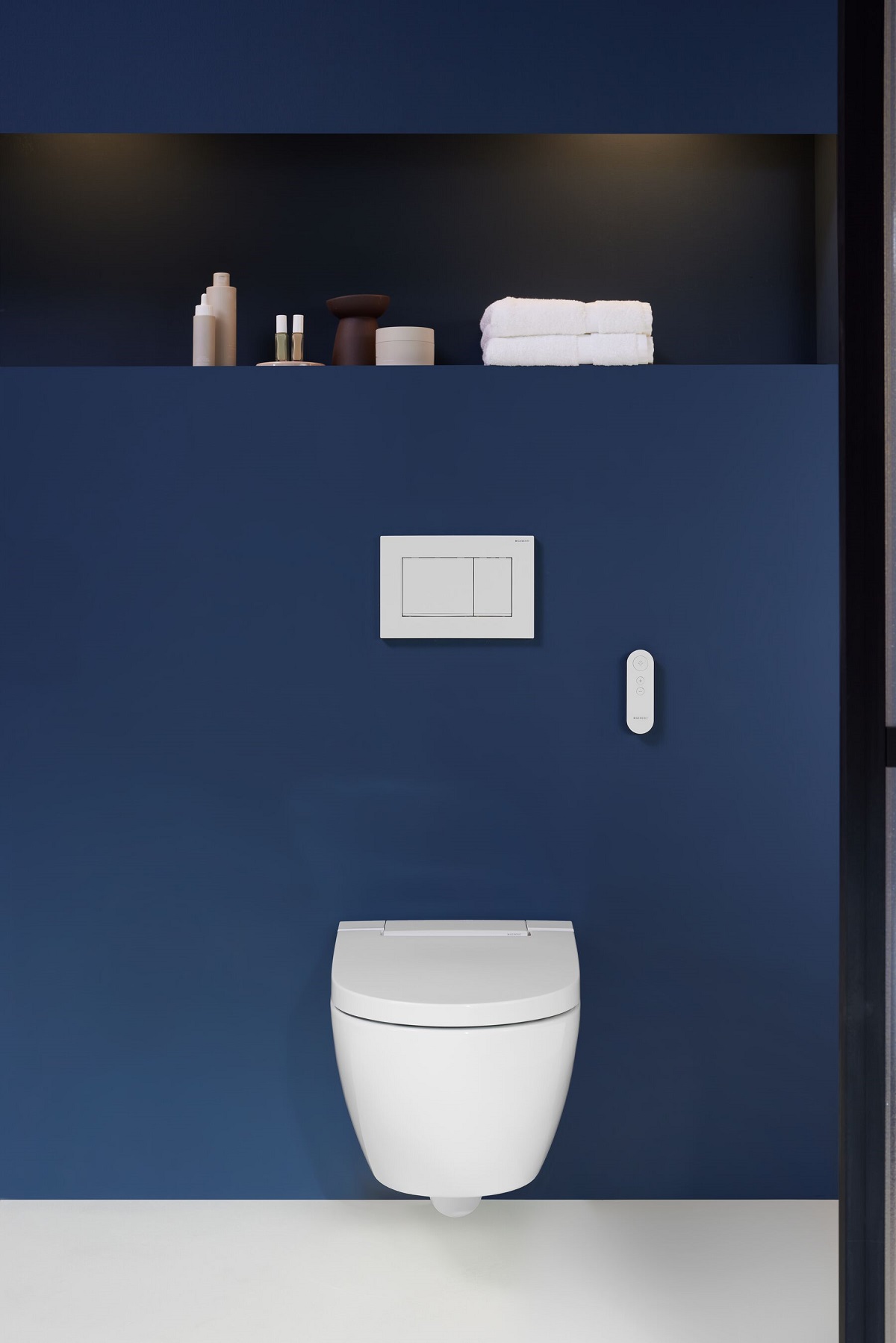 Moderní design snoubený s pohodlím: sprchovací WC AquaClean Alba se stylovým splachovacím tlačítkem a dálkovým ovládáním.